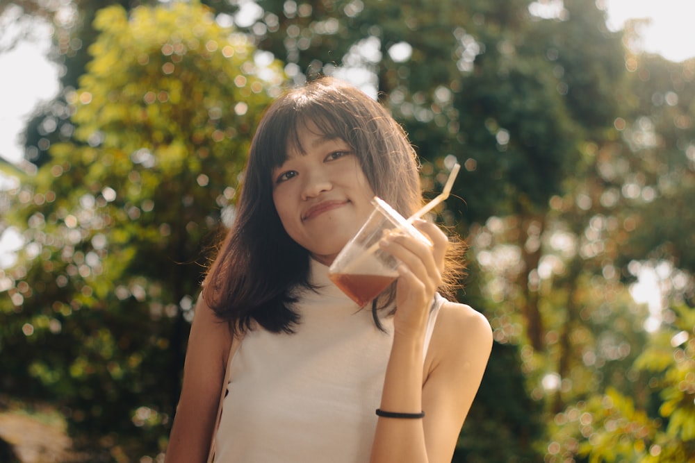 a woman holding a glass of wine in front of her face