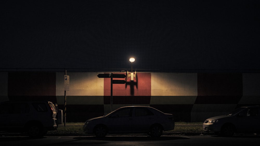 two cars parked in a parking lot at night