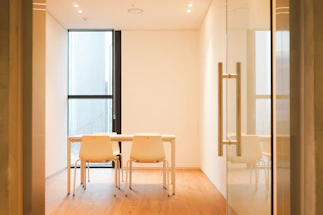 A cozy office meeting room with a wooden conference table and natural light.