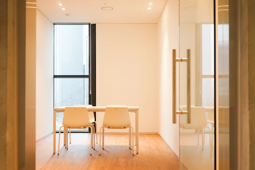 A cozy office meeting room with a wooden conference table and natural light.