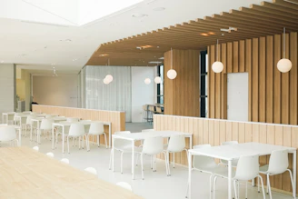 a room with tables and chairs and a wooden wall