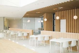 a room with tables and chairs and a wooden wall
