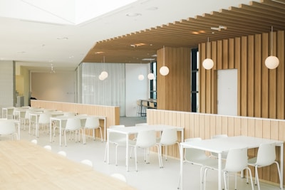 a room with tables and chairs and a wooden wall