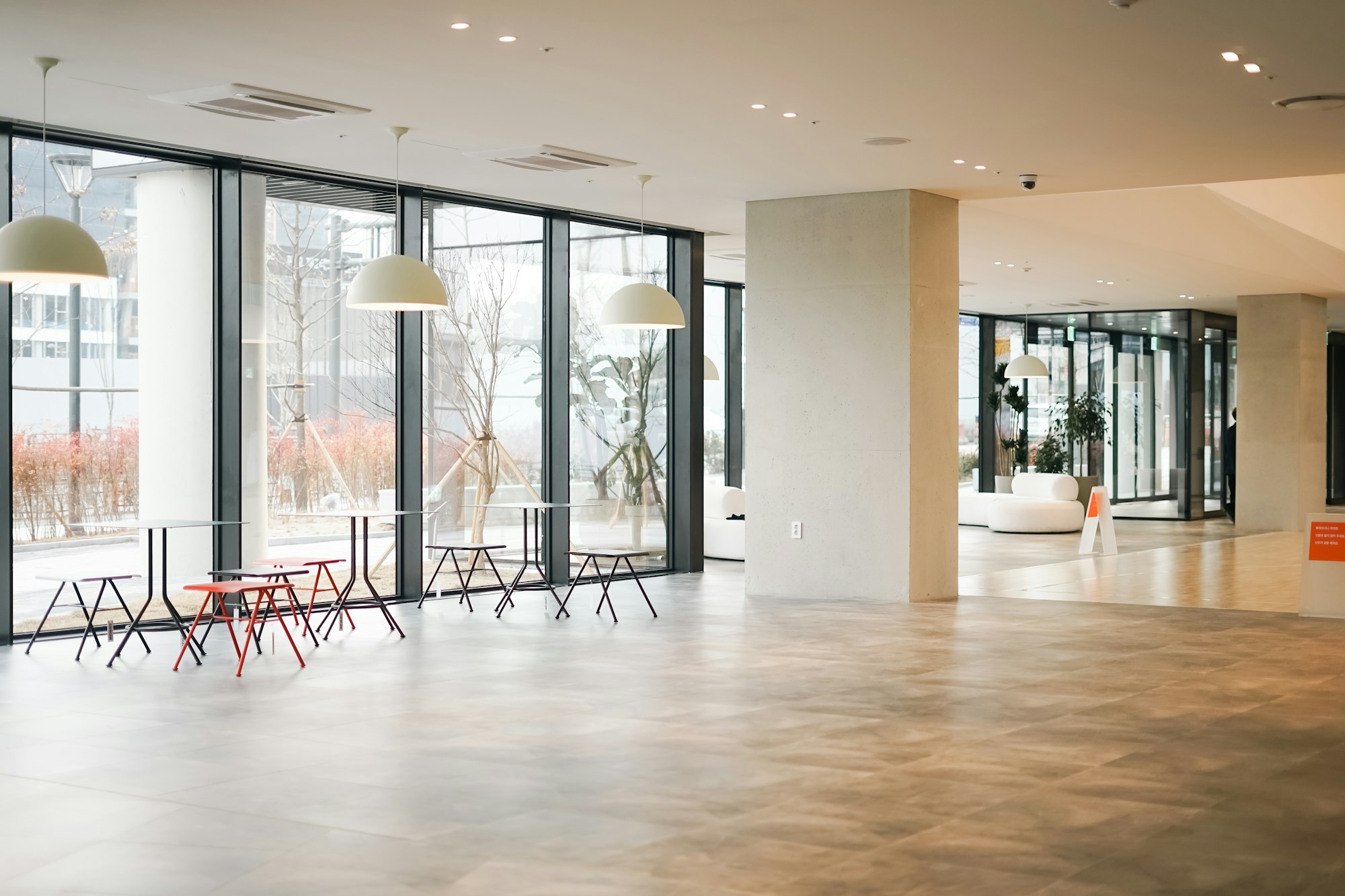 Stone-look luxury vinyl tile across a bright, glass-walled office lobby