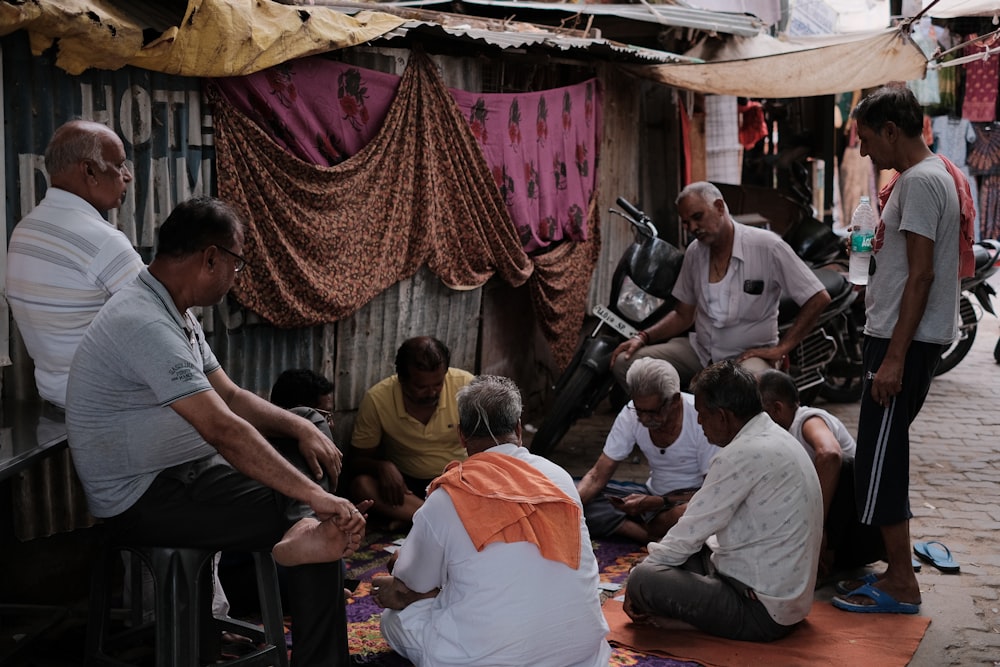 a group of people sitting on the ground in front of a building