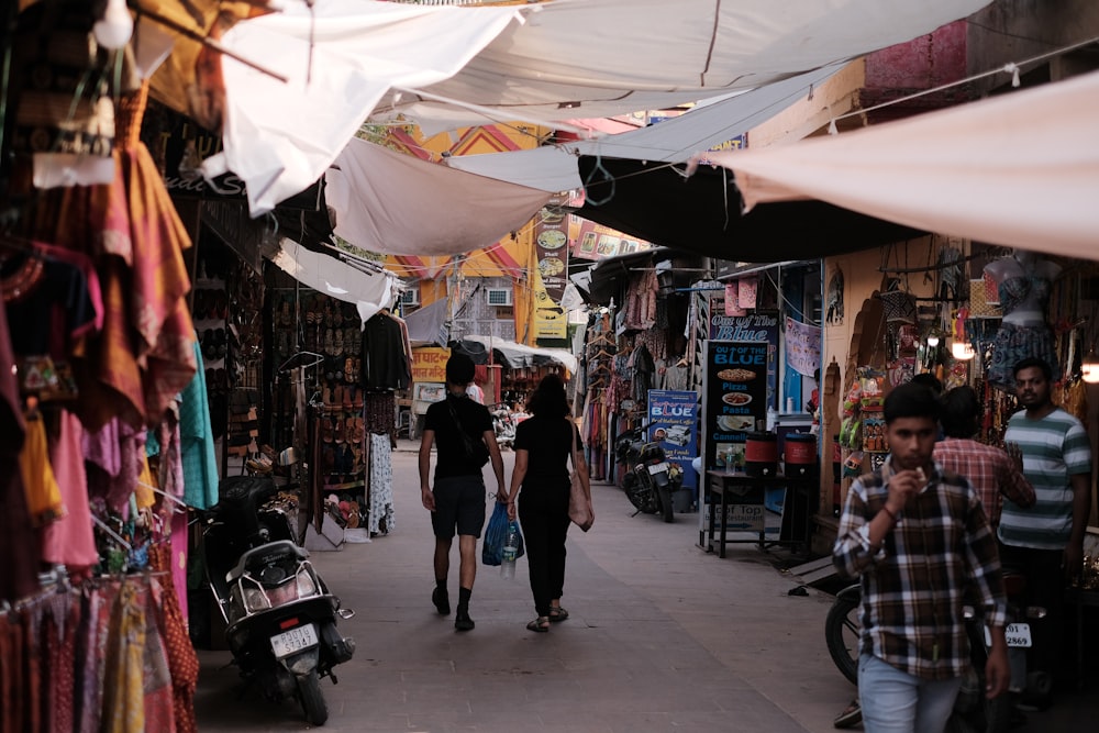 a group of people walking down a street next to shops