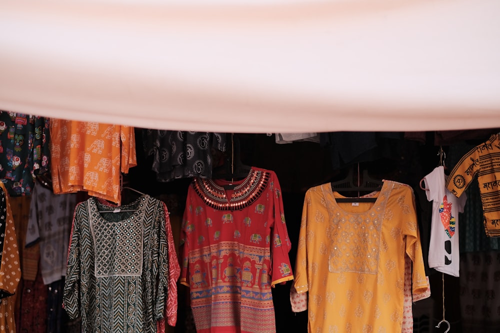 a group of clothes hanging on a rack