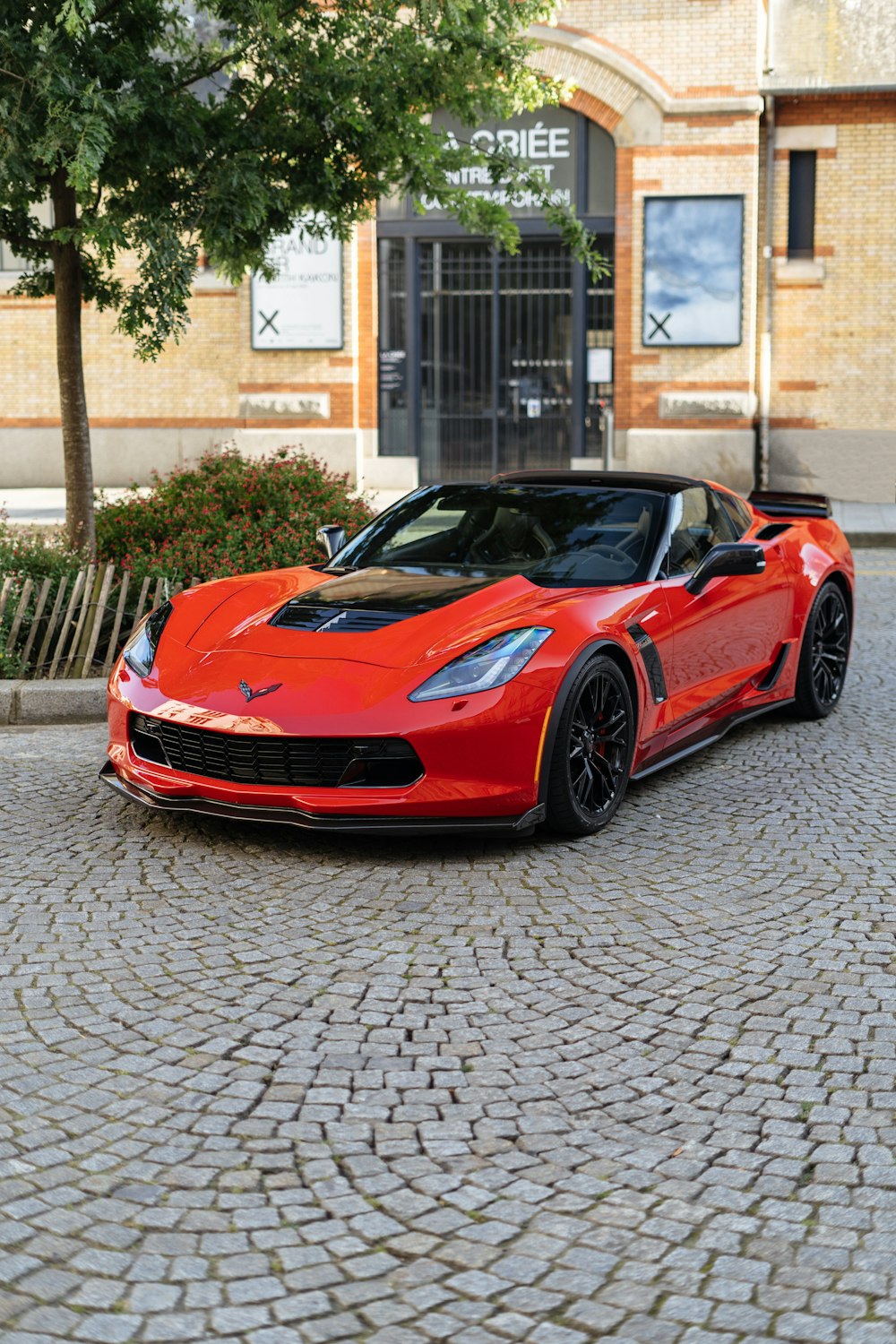a red sports car parked on a cobblestone street