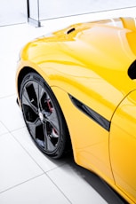 a yellow sports car parked in a showroom