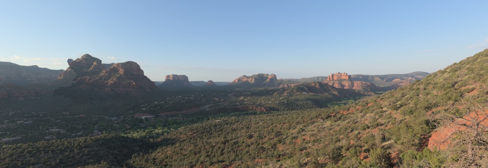 a scenic view of a valley with mountains in the background