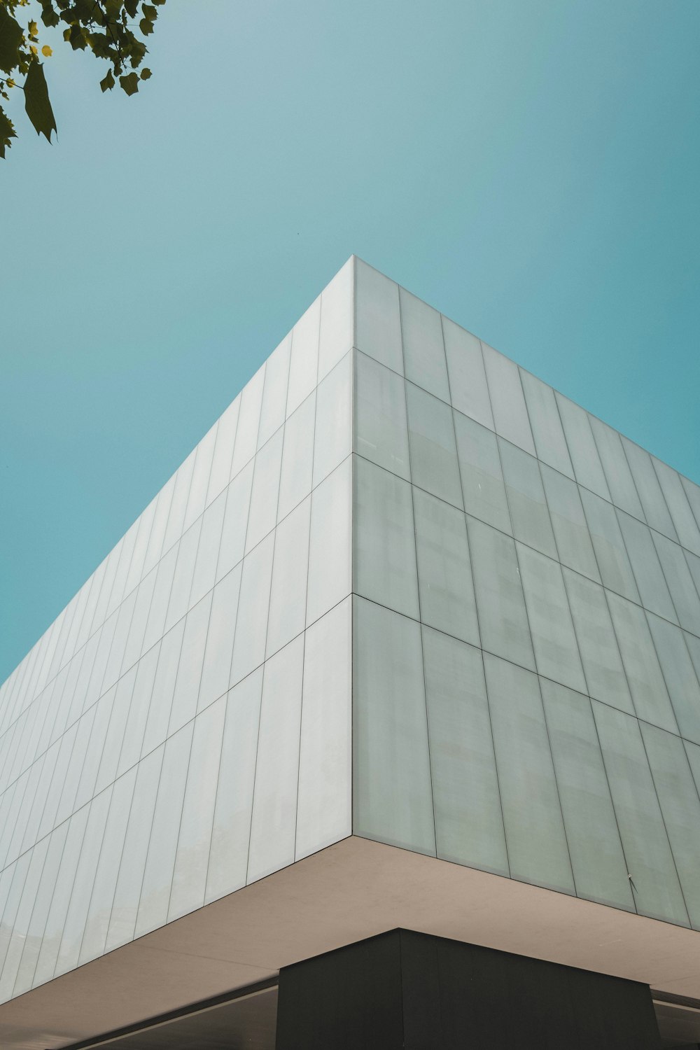 a tall white building sitting under a blue sky