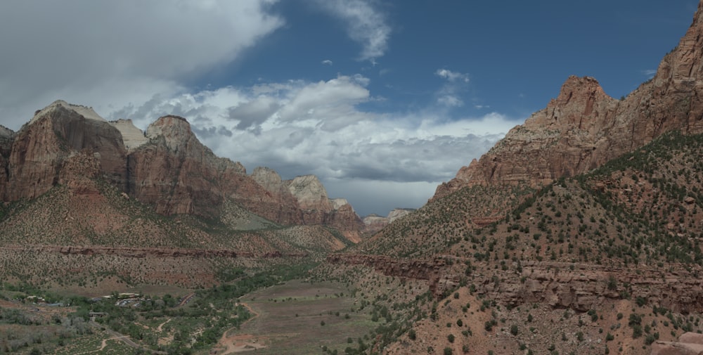 a scenic view of a valley with mountains in the background