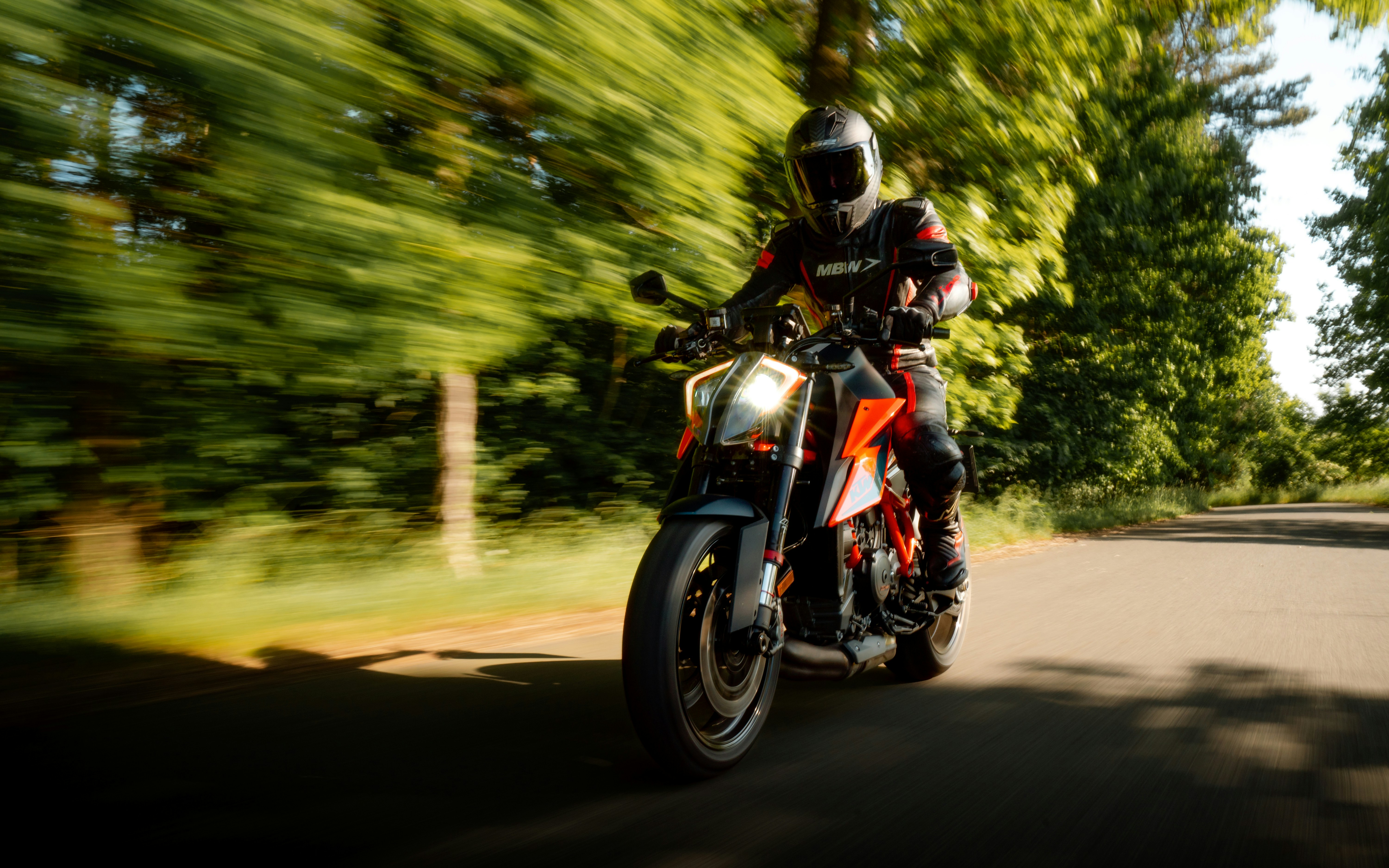 KTM-style sport motorcycle riding on a twisting road, demonstrating real-world braking performance