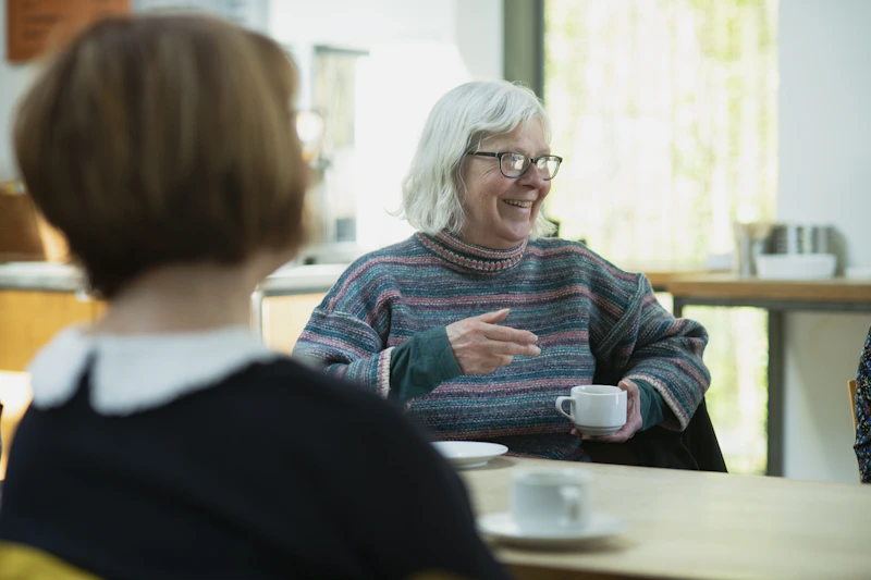 woman talking with another woman at a table