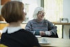 photo of two people sitting at a table chatting