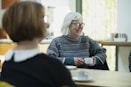 photo of two people sitting at a table chatting