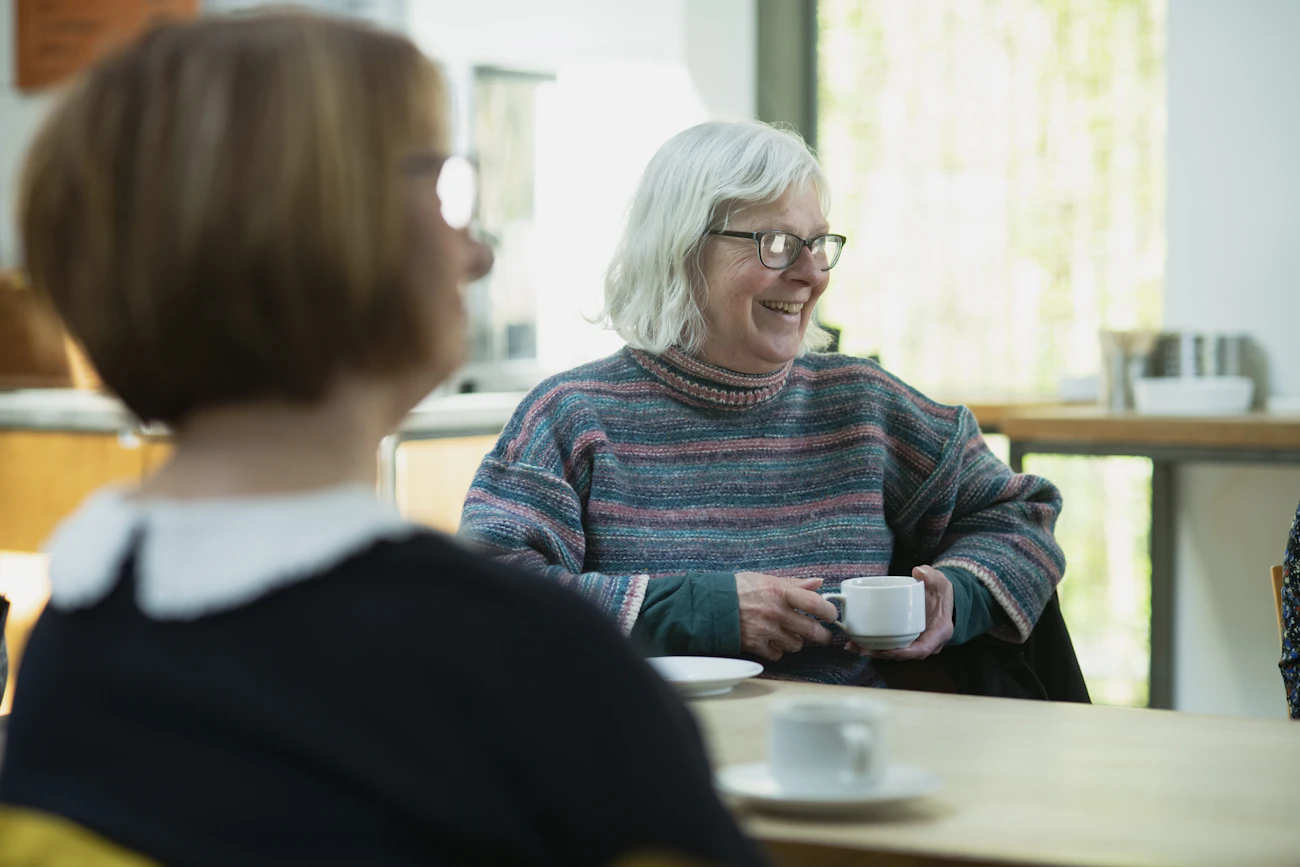 An older woman enjoying tea and conversation