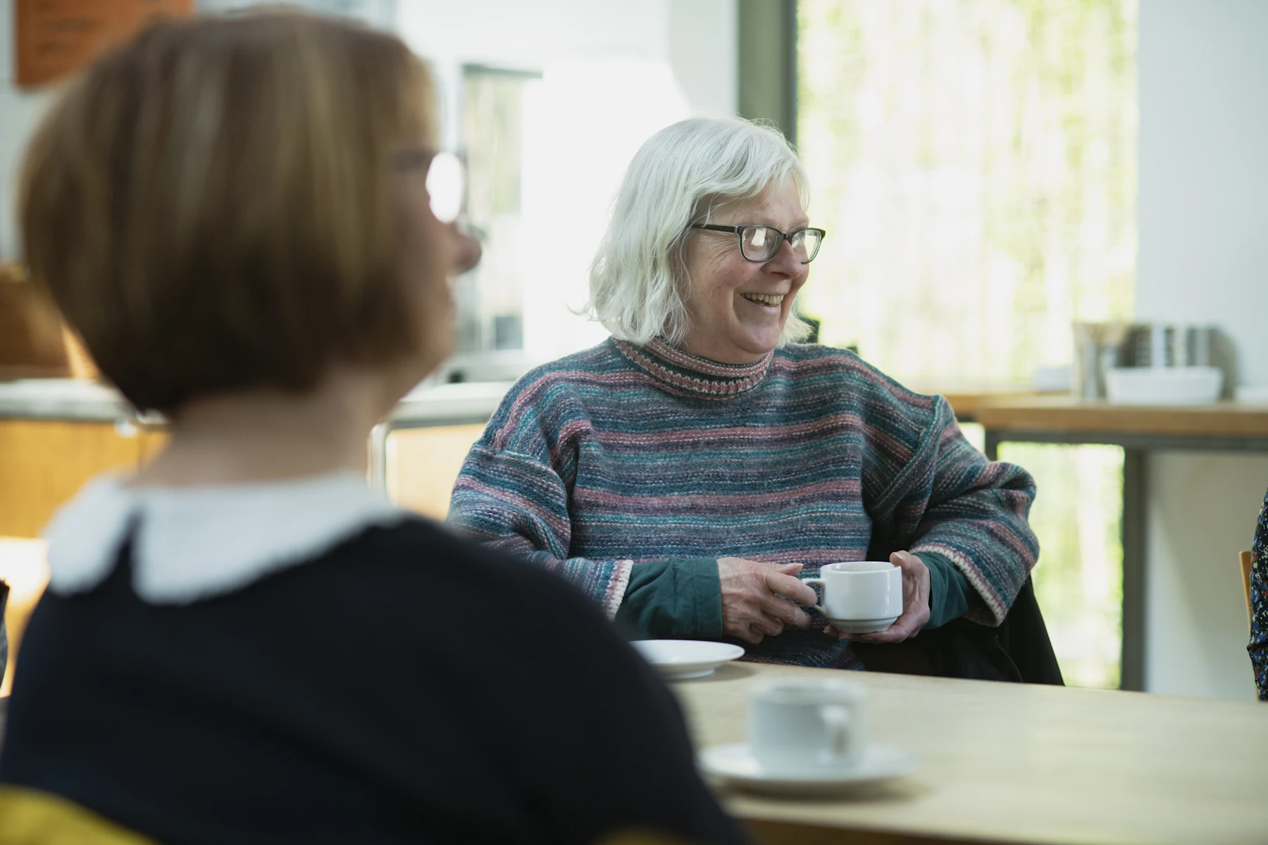 An older woman enjoying tea and conversation