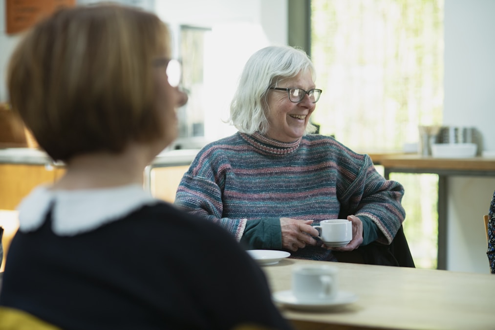 Two friends sitting on a couch talking to each other