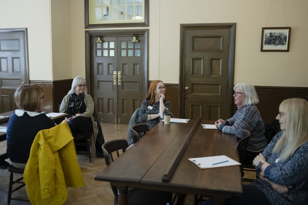 a group of women sitting around a wooden table