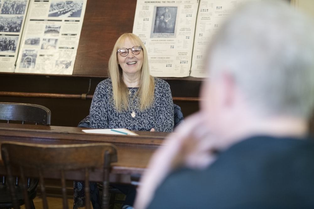 a woman sitting at a table in front of a man