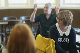 A staff member providing guidance to a person with developmental disabilities in a cozy room.