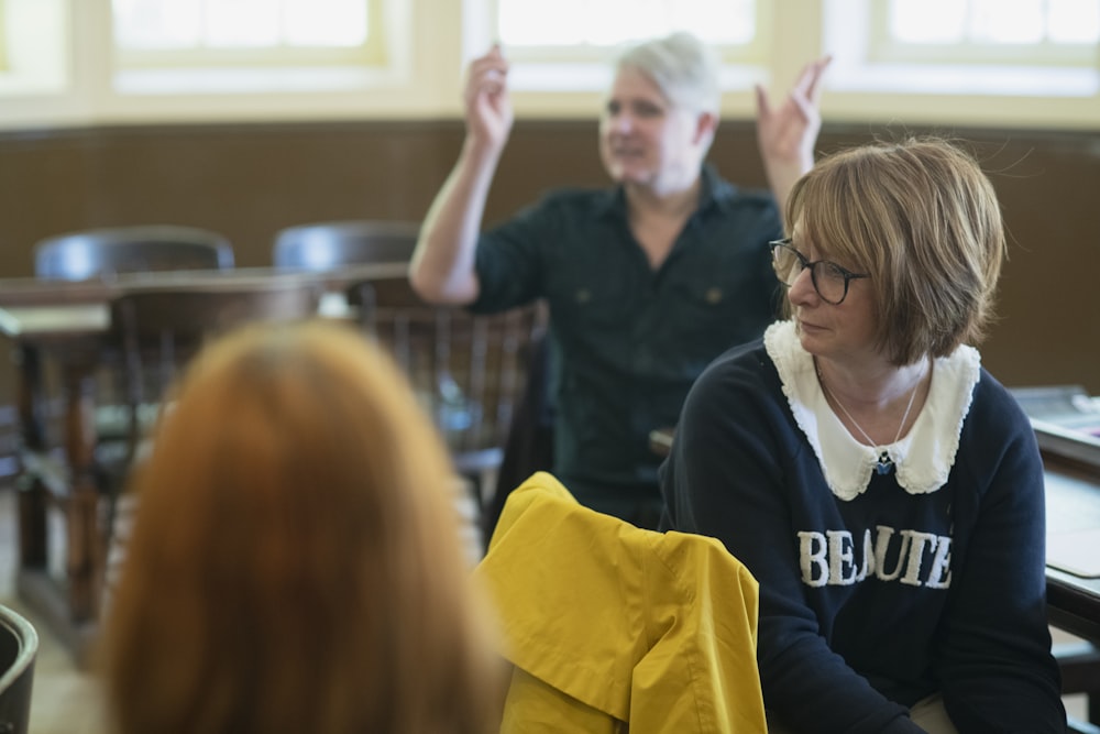 a woman sitting in front of a man in a classroom