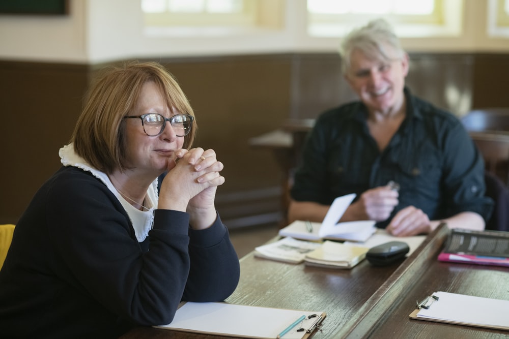 a woman sitting at a table with two other people