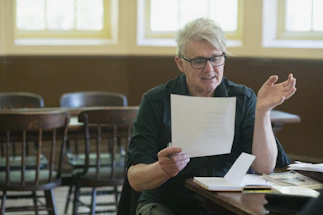 A friendly instructor assisting a student with VTC exam paperwork in a bright office.