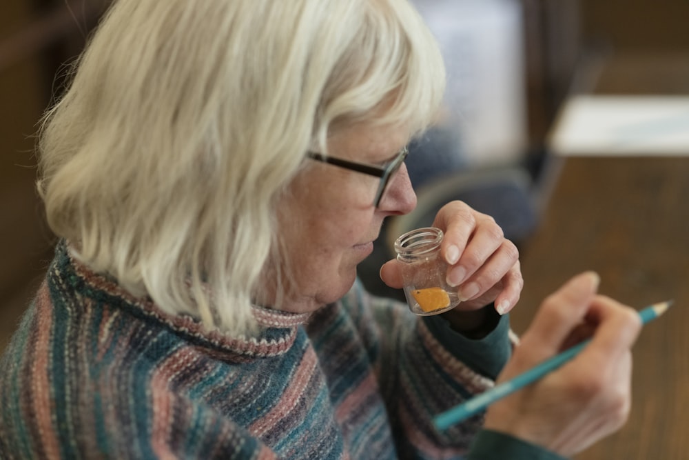 an older woman holding a glass of liquid