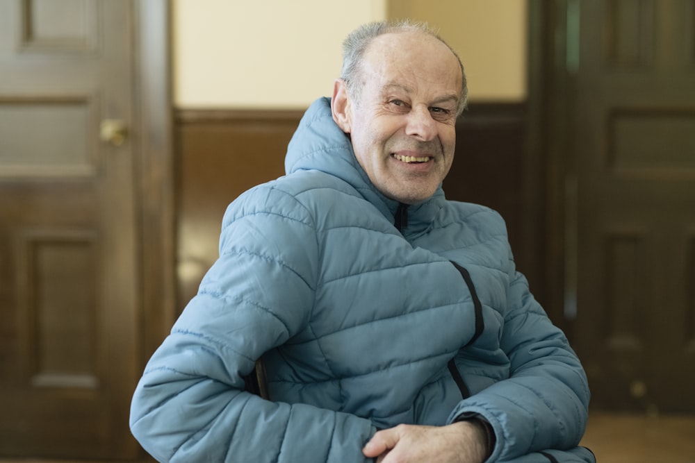 a man in a blue jacket is sitting down