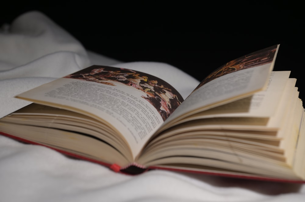 an open book sitting on top of a bed