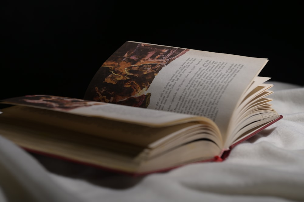 an open book sitting on top of a bed