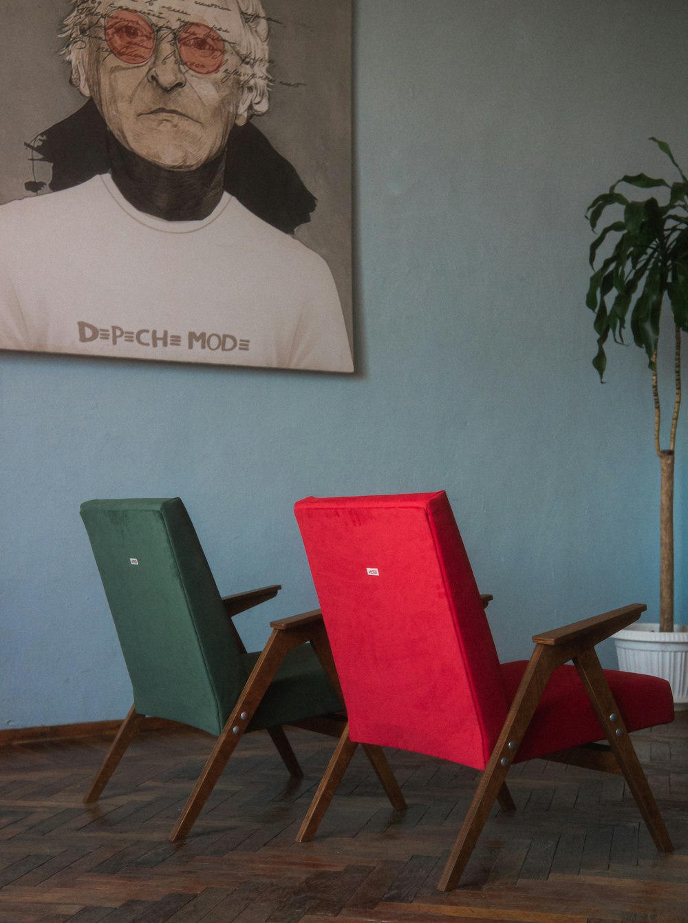 a couple of chairs sitting in front of a painting