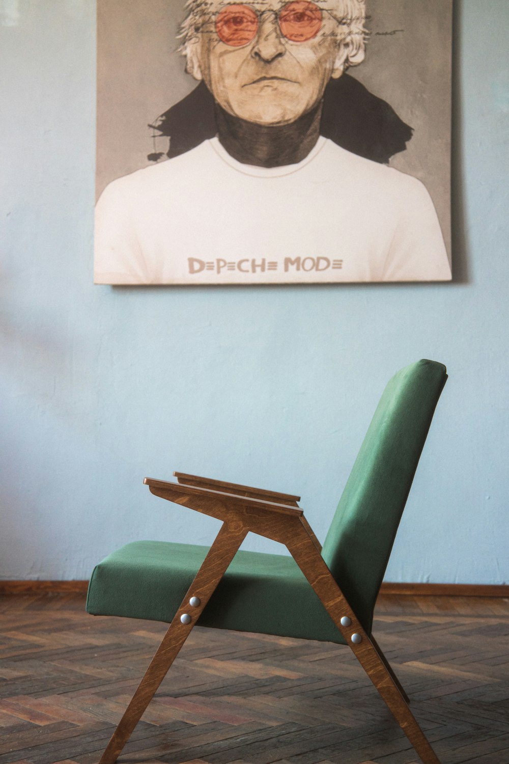 a green chair sitting in front of a painting