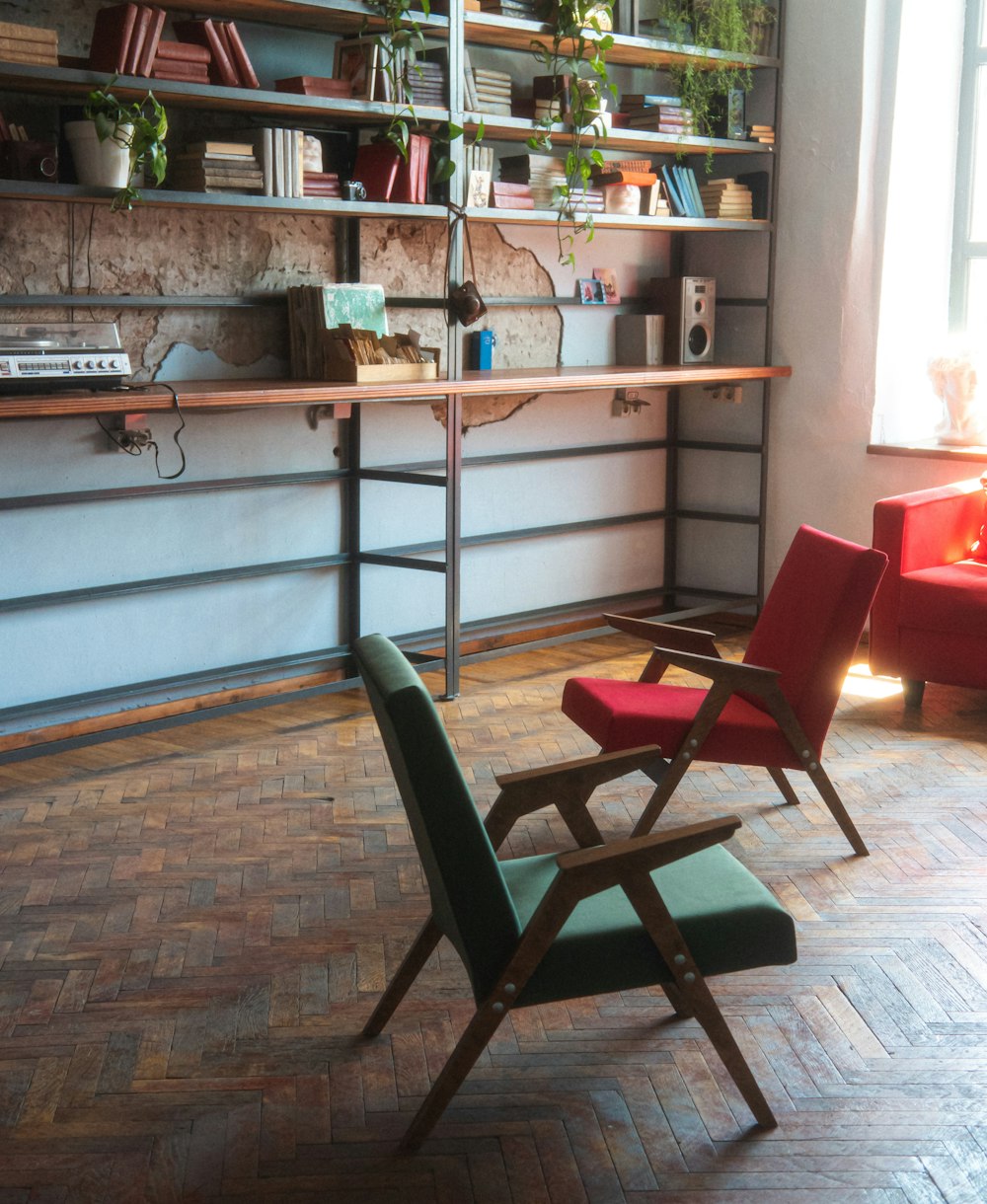 two chairs sitting in a room next to a book shelf