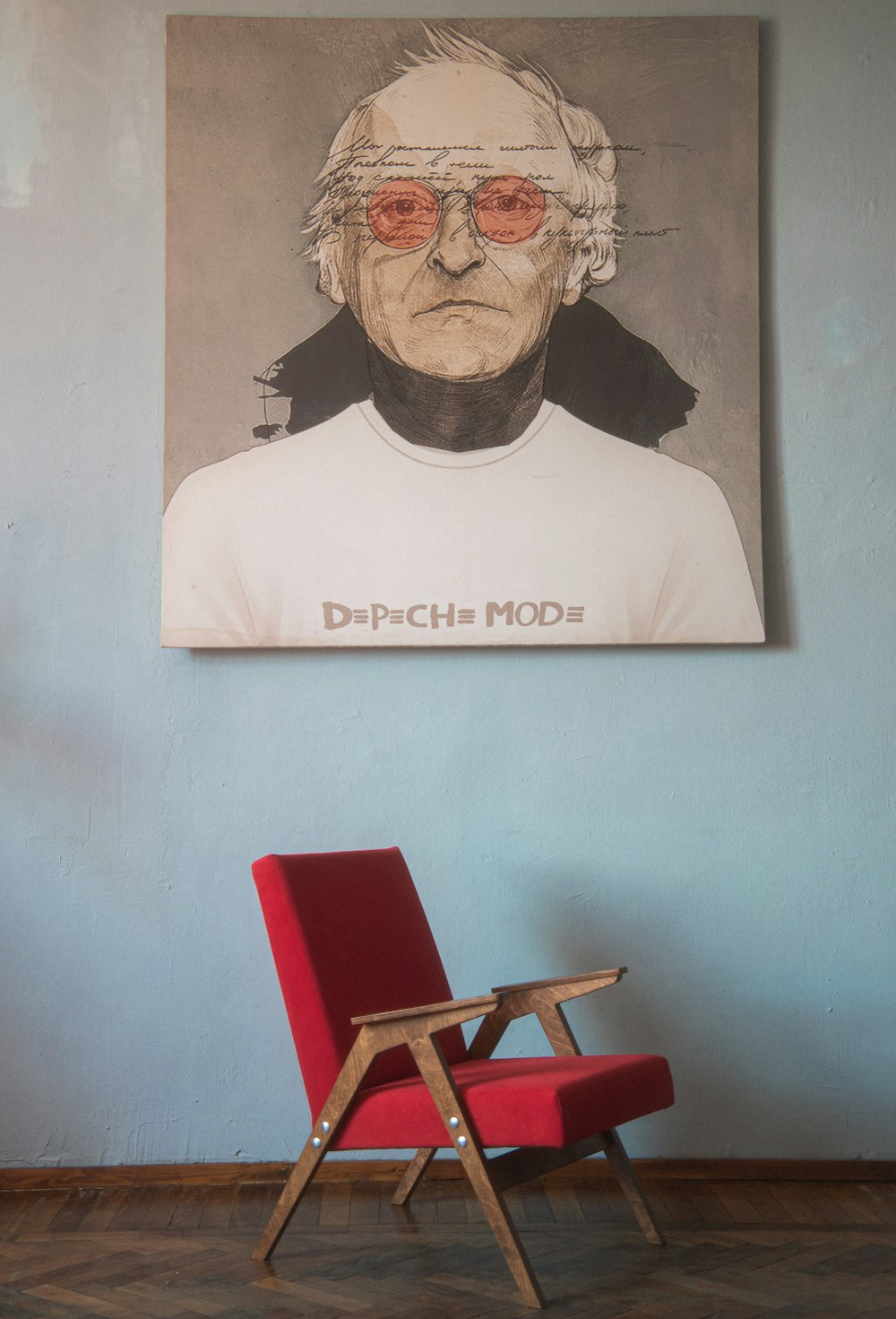 a red chair sitting in front of a painting