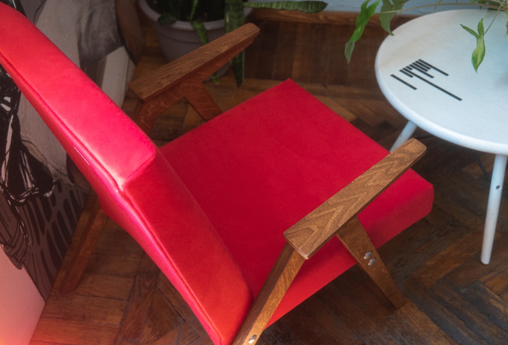 a red chair sitting next to a white table