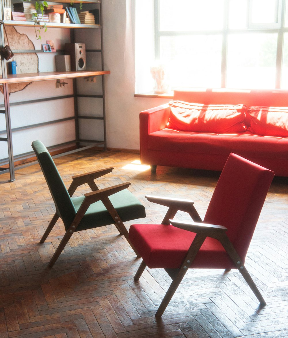 a living room with a red couch and two chairs