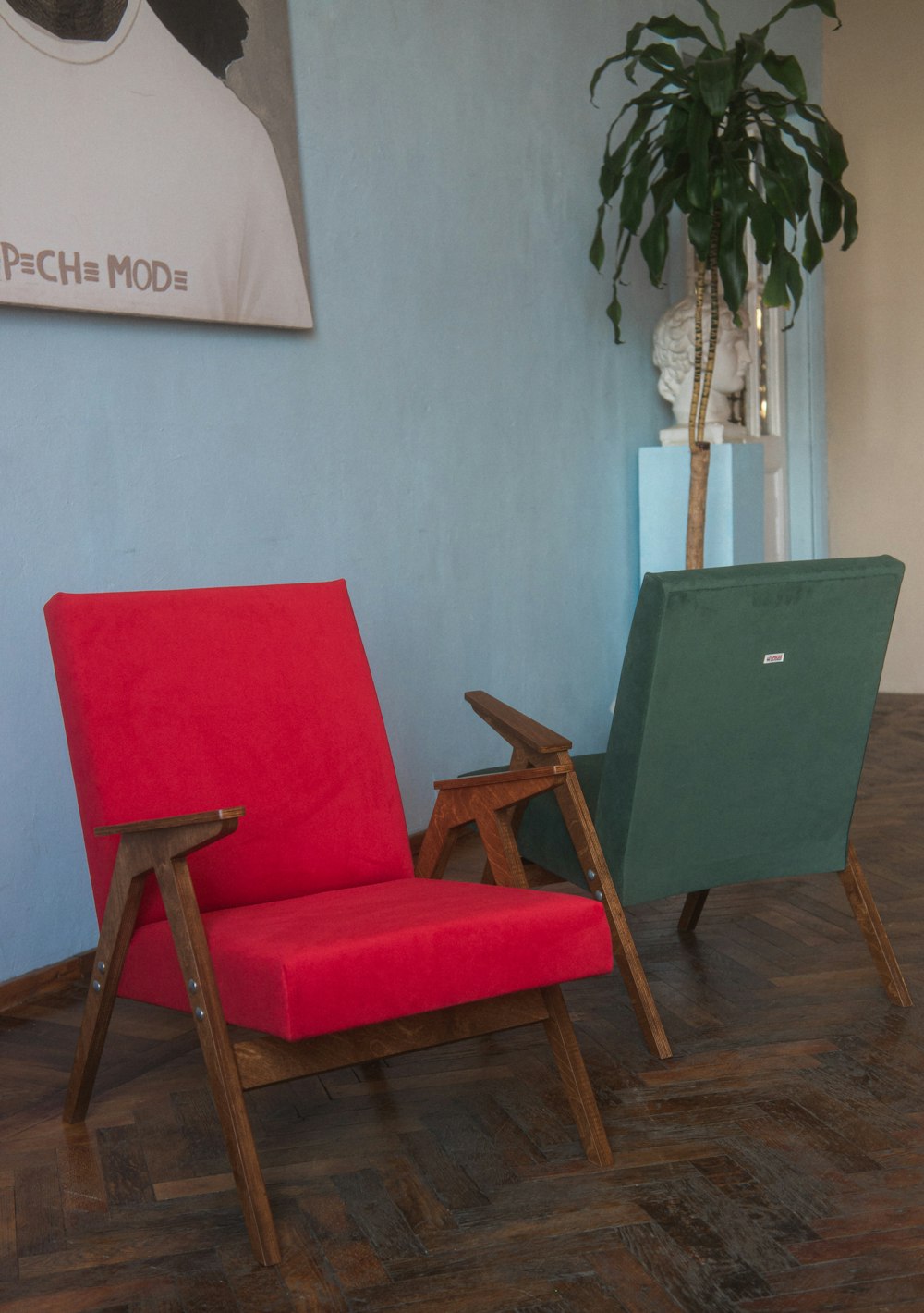 a red chair sitting next to a green chair