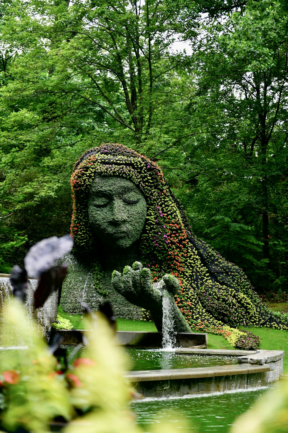 a statue of a woman covered in flowers