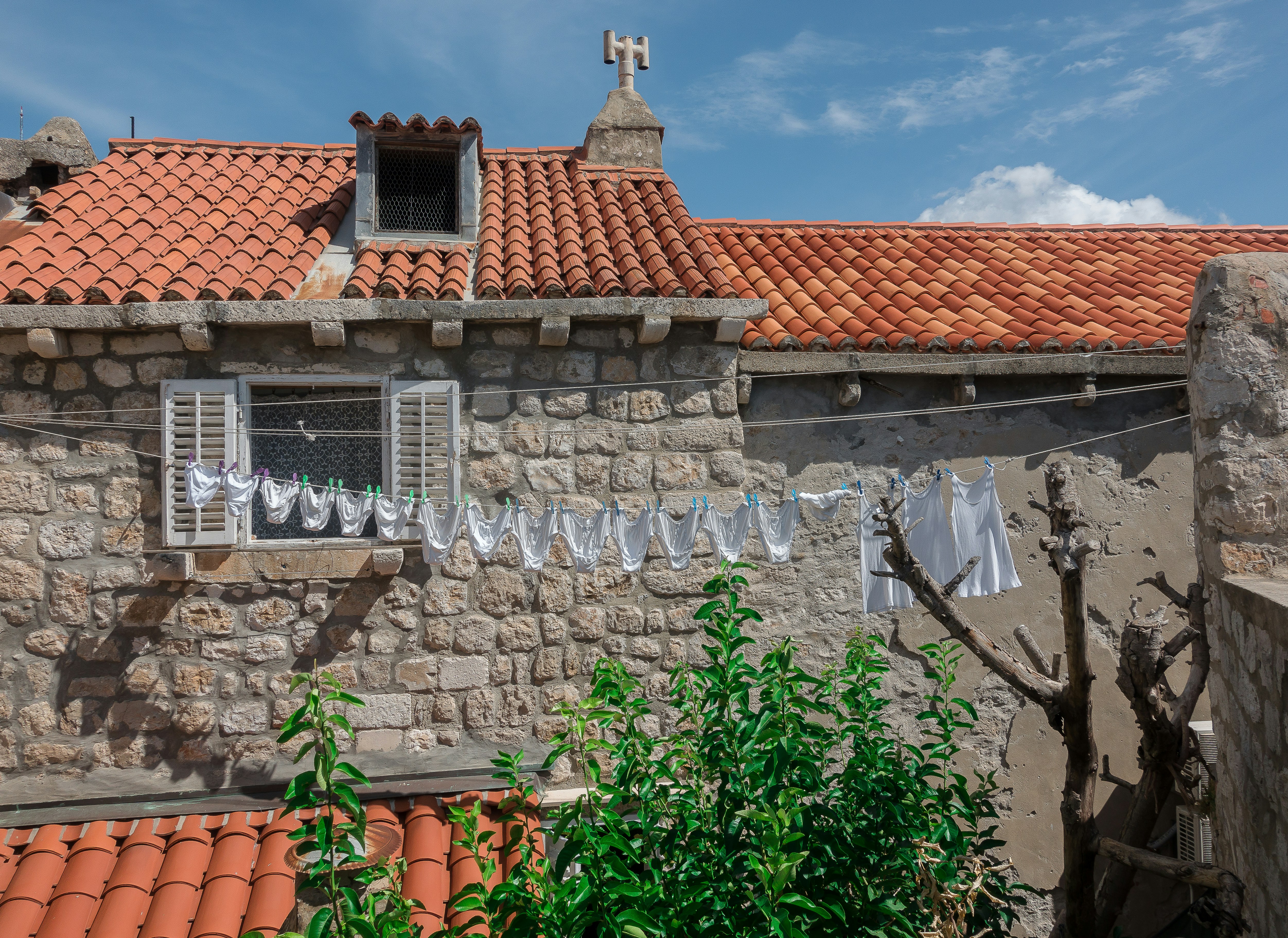 un bâtiment en pierre avec un toit de tuiles rouges