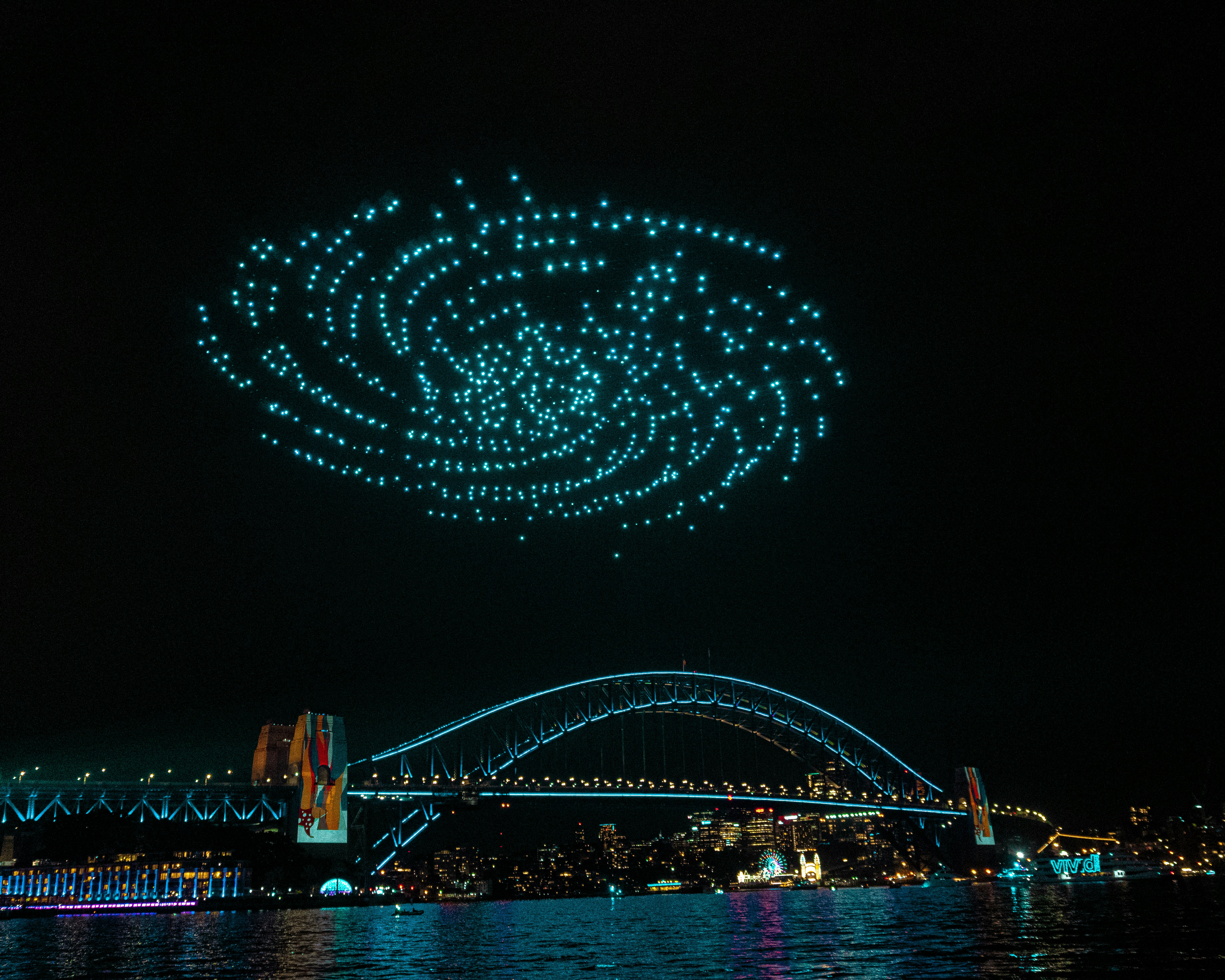 a group of people flying kites over a body of water