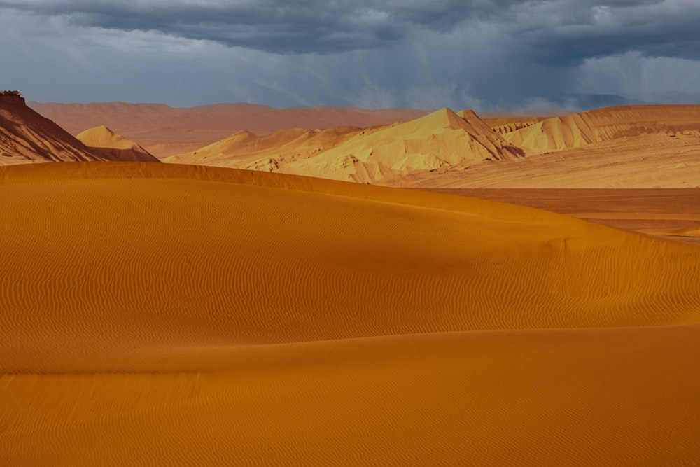Un désert avec des dunes de sable et des montagnes en arrière-plan
