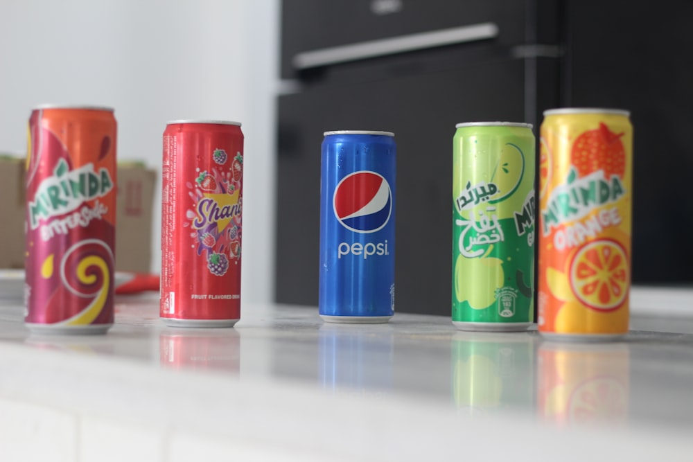 a row of soda cans sitting on top of a counter