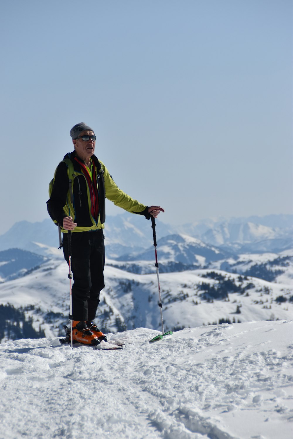 a man standing on top of a snow covered slope