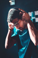 A young girl wearing headphones, smiling as she adjusts sound levels on a laptop.