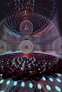 A mesmerizing digital artwork featuring intricate geometric patterns with three large spherical structures at the center. The spheres appear to be composed of thin, transparent meshes surrounded by a vast array of glimmering, faceted elements reminiscent of crystalline forms. The scene is set within a reflective environment that amplifies the complexity and beauty of the design.
