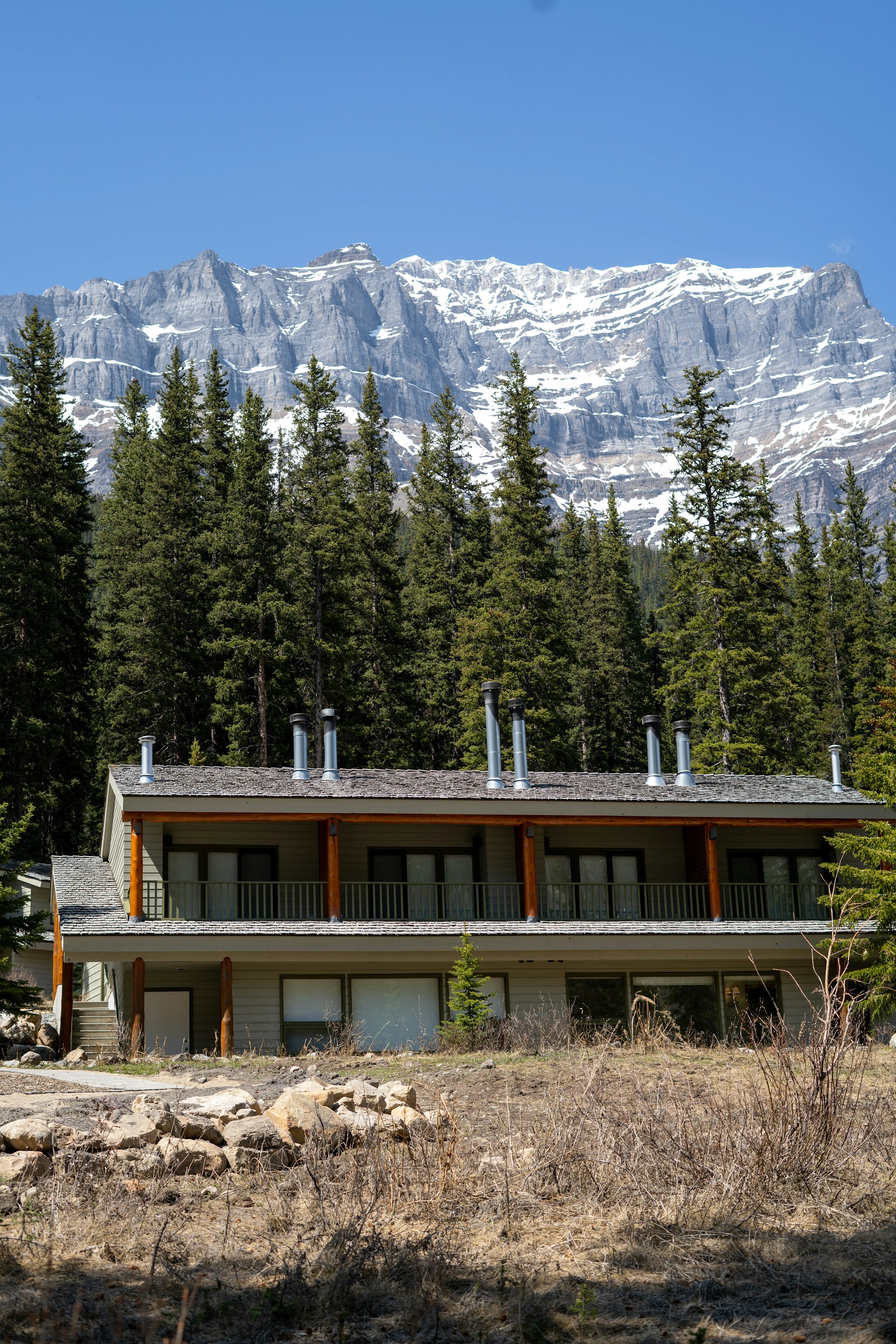 Timber-and-stone Alder & Stone home below a snow-capped Wasatch ridge