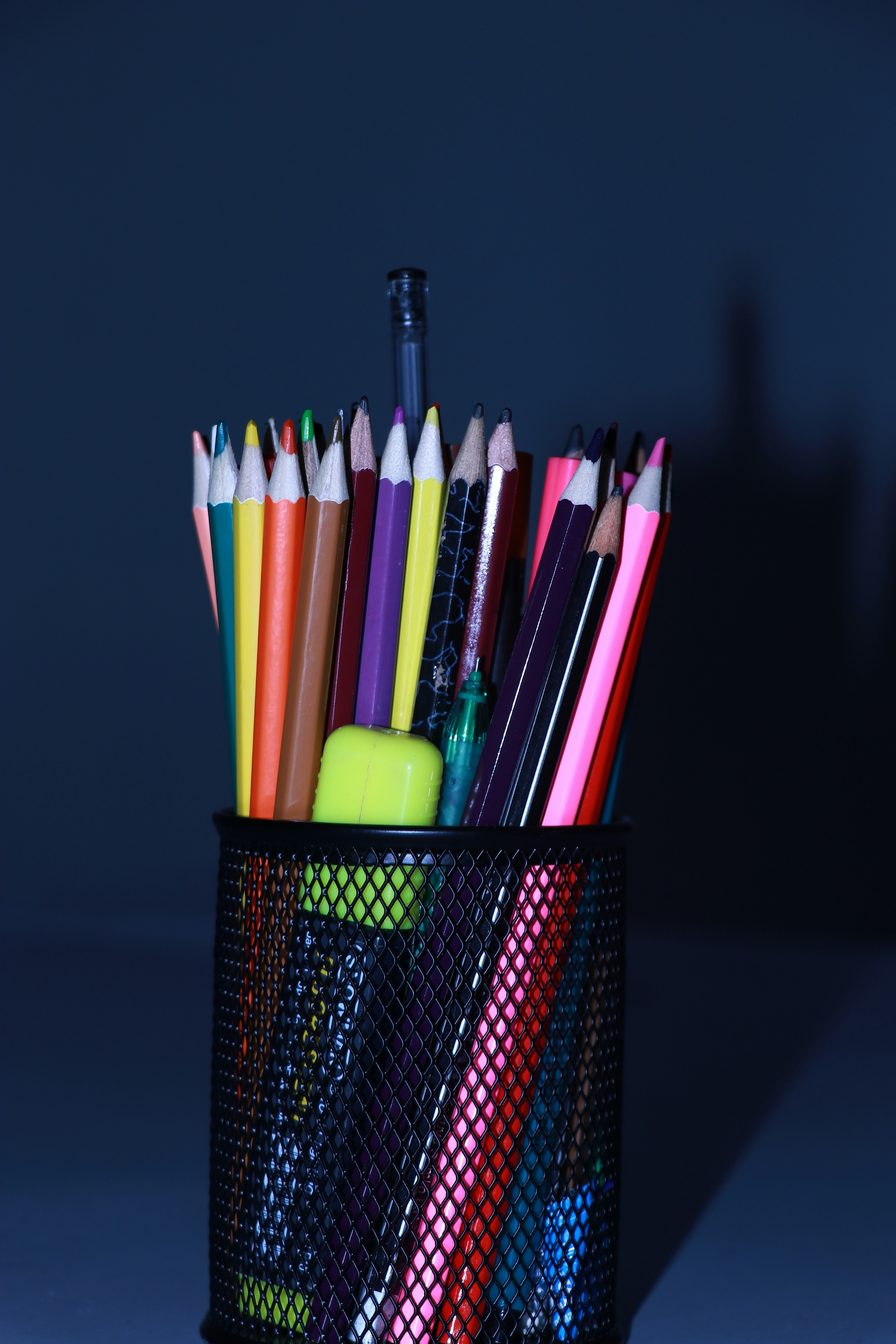 a cup filled with lots of different colored pencils